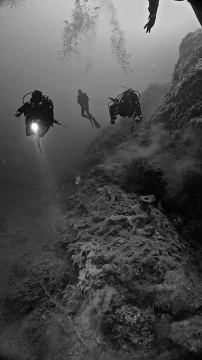 Foto Diving Chia: Tre sub, una torcia, una parete. Il silenzio totale del Mediterraneo profondo.