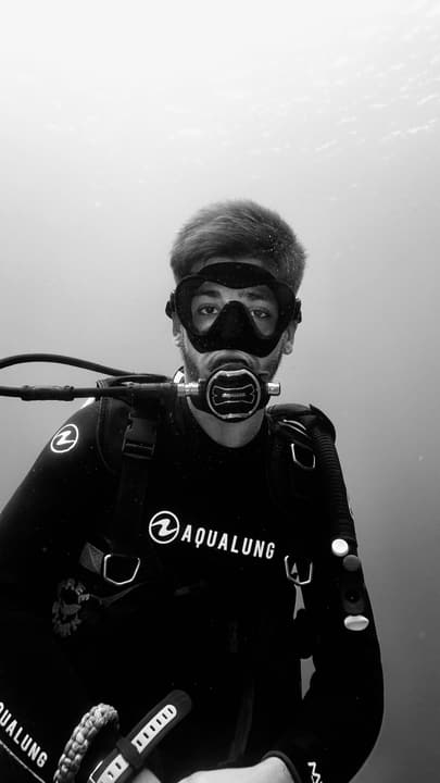 Foto Diving Chia: Ritratto da copertina. La luce dall'alto, l'erogatore in centro, il resto è sguardo.
