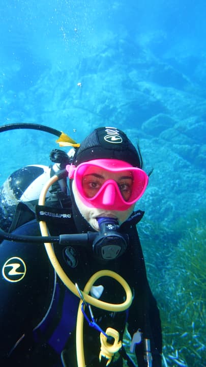Foto Diving Chia: Sorriso sotto la maschera fucsia. Si vede tutto, anche con il boccaglio in bocca.